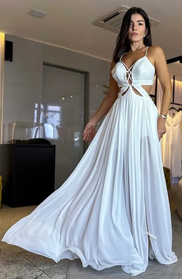 Vestido branco com alças finas, recorte na cintura e uma leve transparência na saia. Perfeito para réveillon na praia